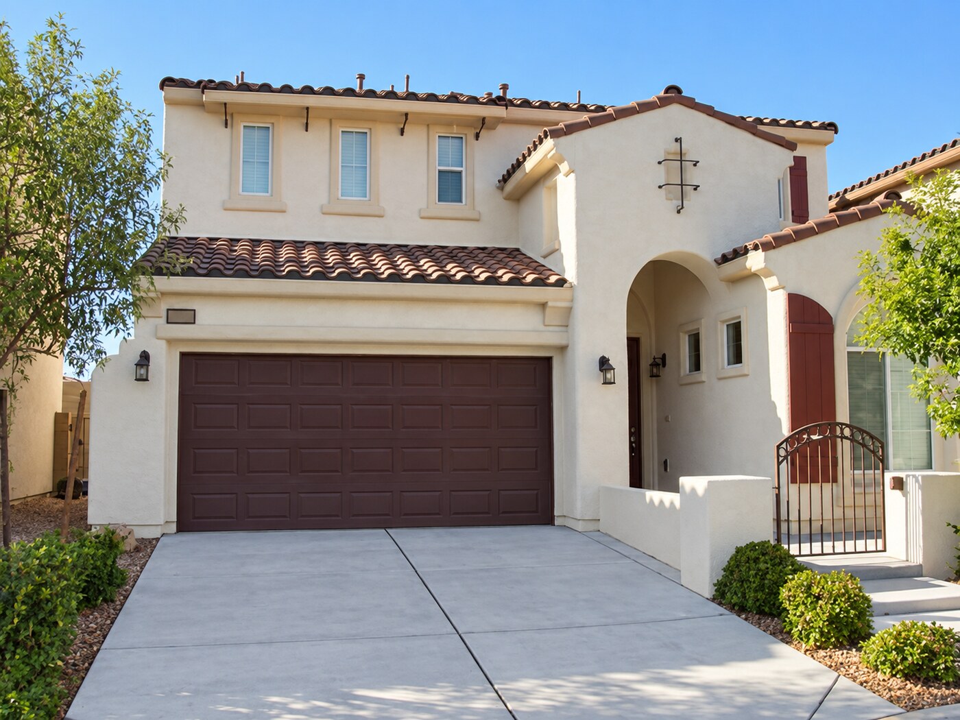 Two-story stucco home with arched entry and tile roof