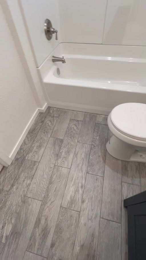 Bathroom with wood-look tile floor and tub