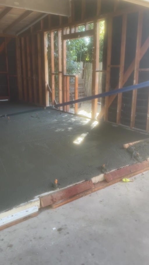 Fresh concrete poured over the existing slab to level the floor