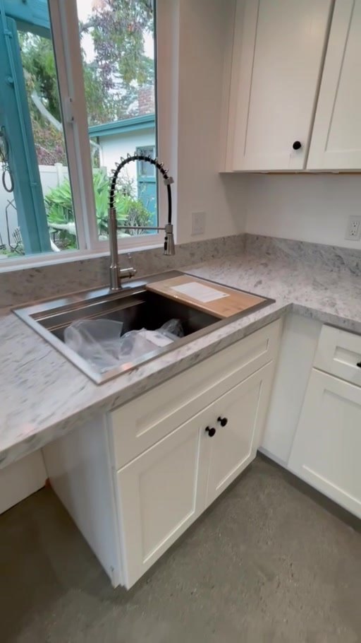 Quartz countertop and sink below a window