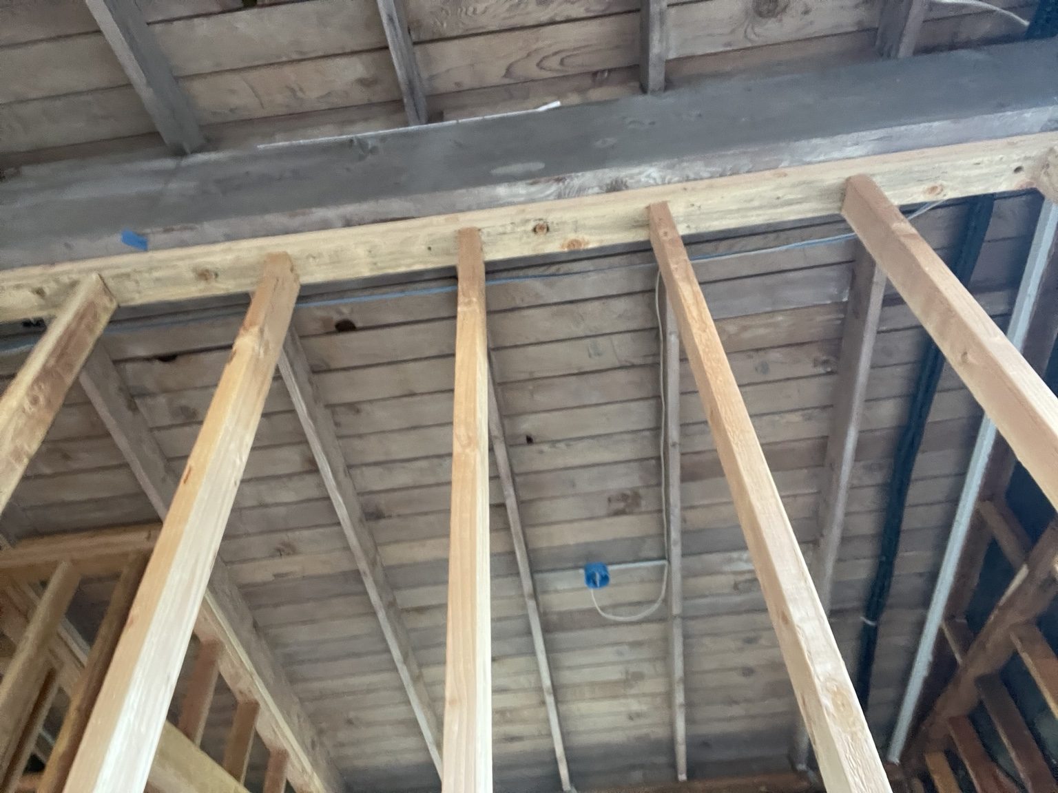 Existing garage ridge beam and roof boards kept above new framing
