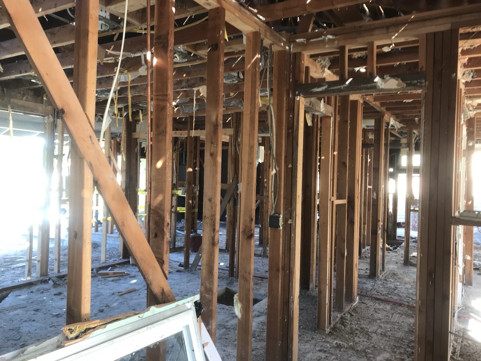 Interior framing of the fire-damaged home stripped to the studs before demolition