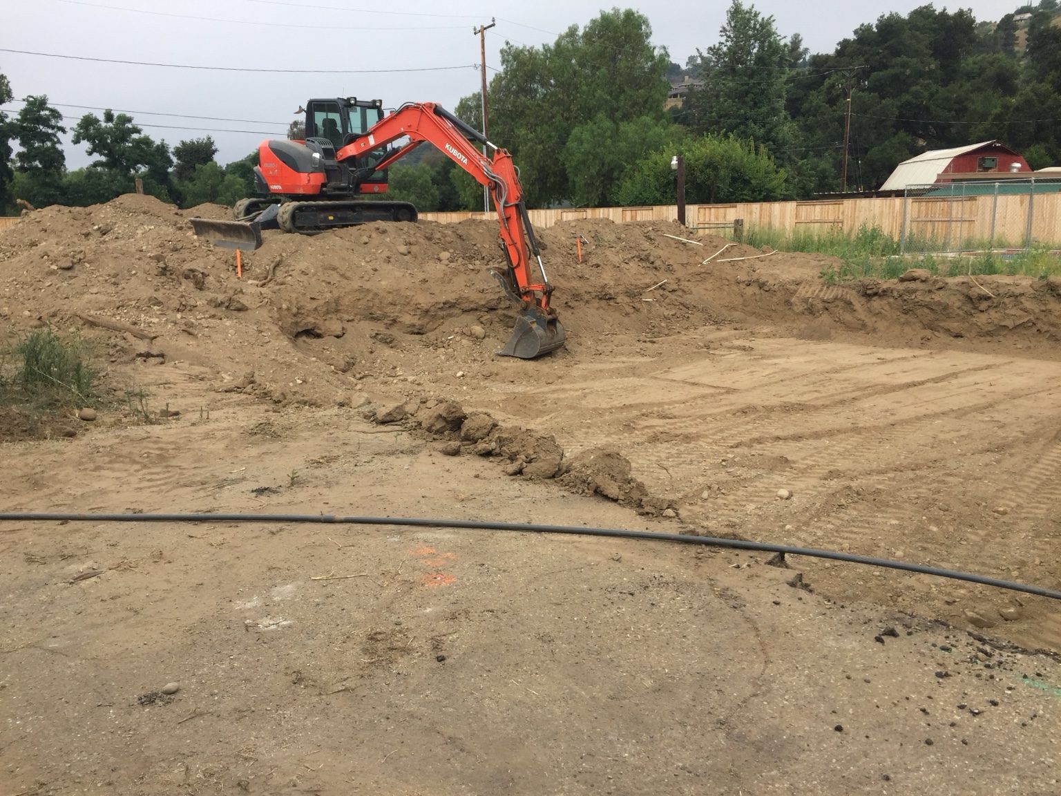 Excavator over-excavating soil for the new garage pad
