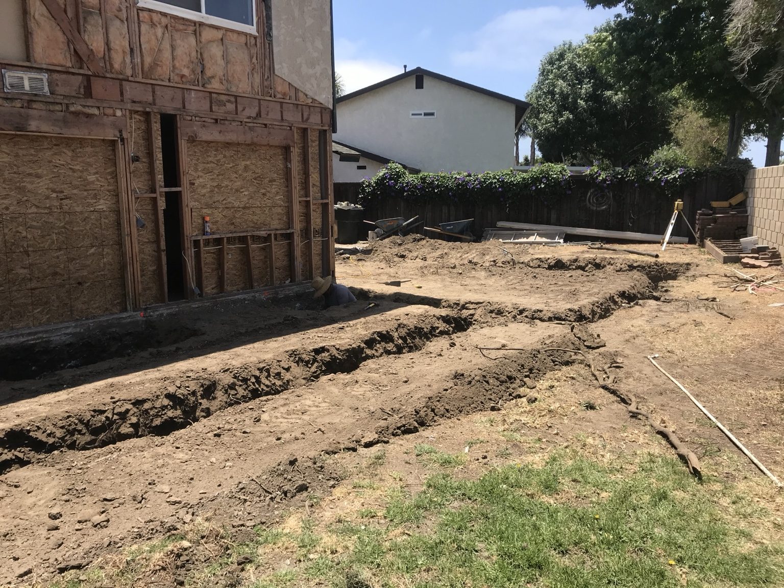 Footing trenches dug in the back yard alongside the existing house