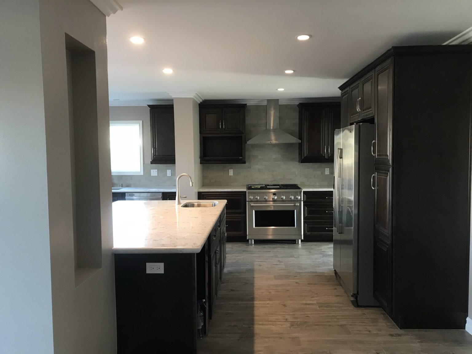 Kitchen range wall with hood, tile backsplash and maple cabinets