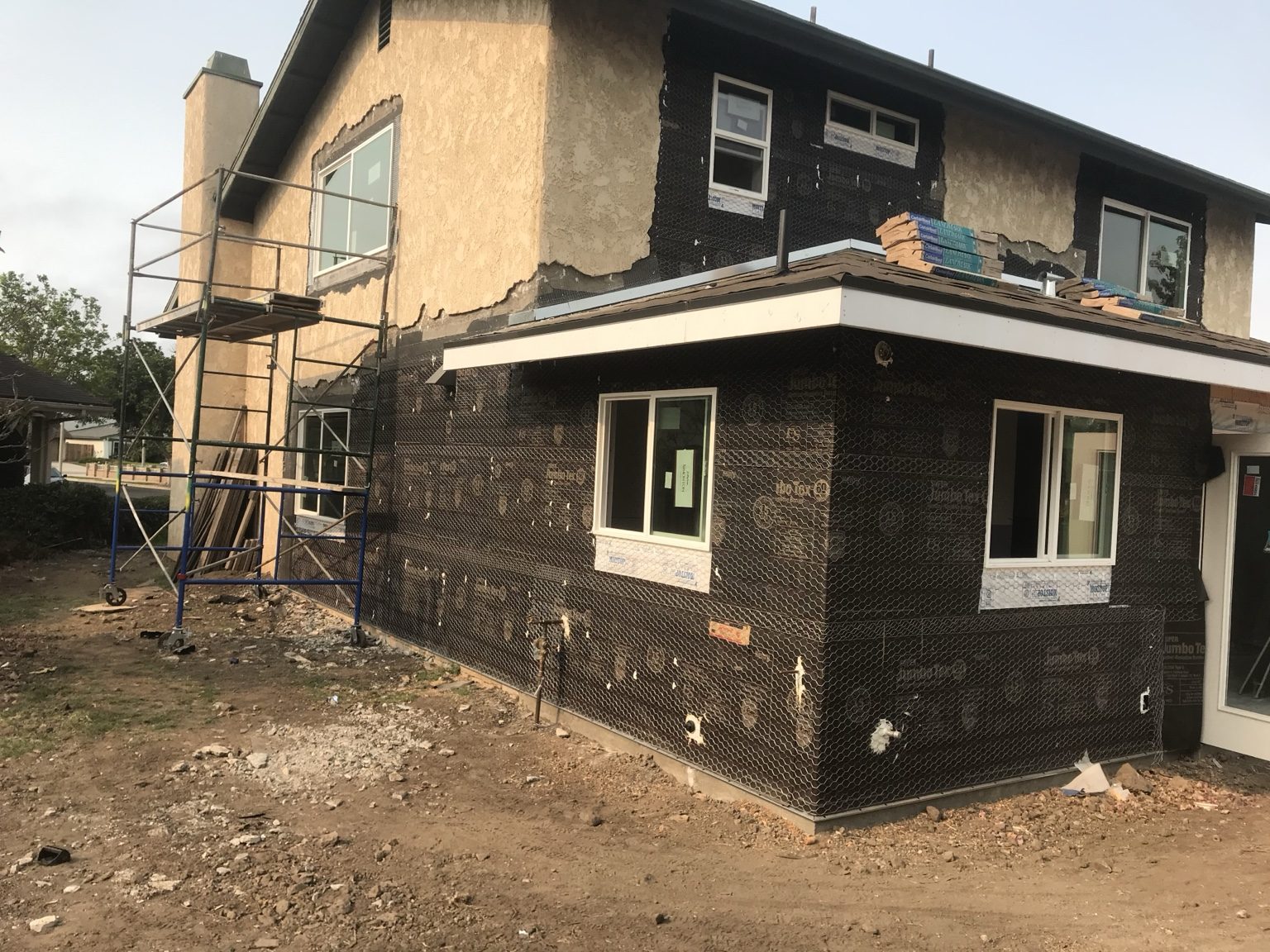 Stucco lath on the addition with new windows installed throughout the house