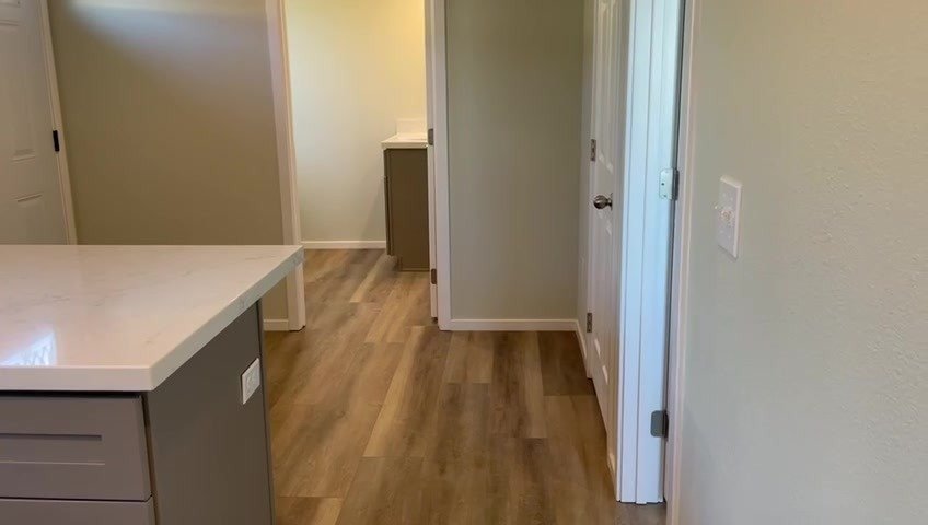 Hallway with LVP flooring and six-panel doors