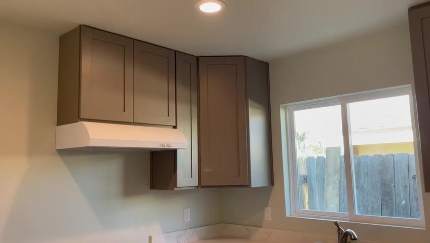 ADU kitchen with birch cabinets, quartz counters and a window over the sink