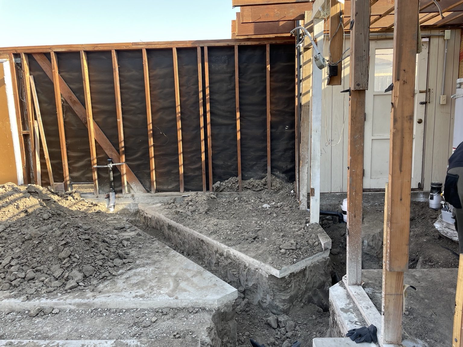 Trench excavated beside the garage for the sewer connection