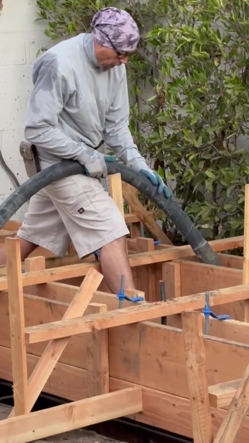 Crew pumping concrete into the foundation forms
