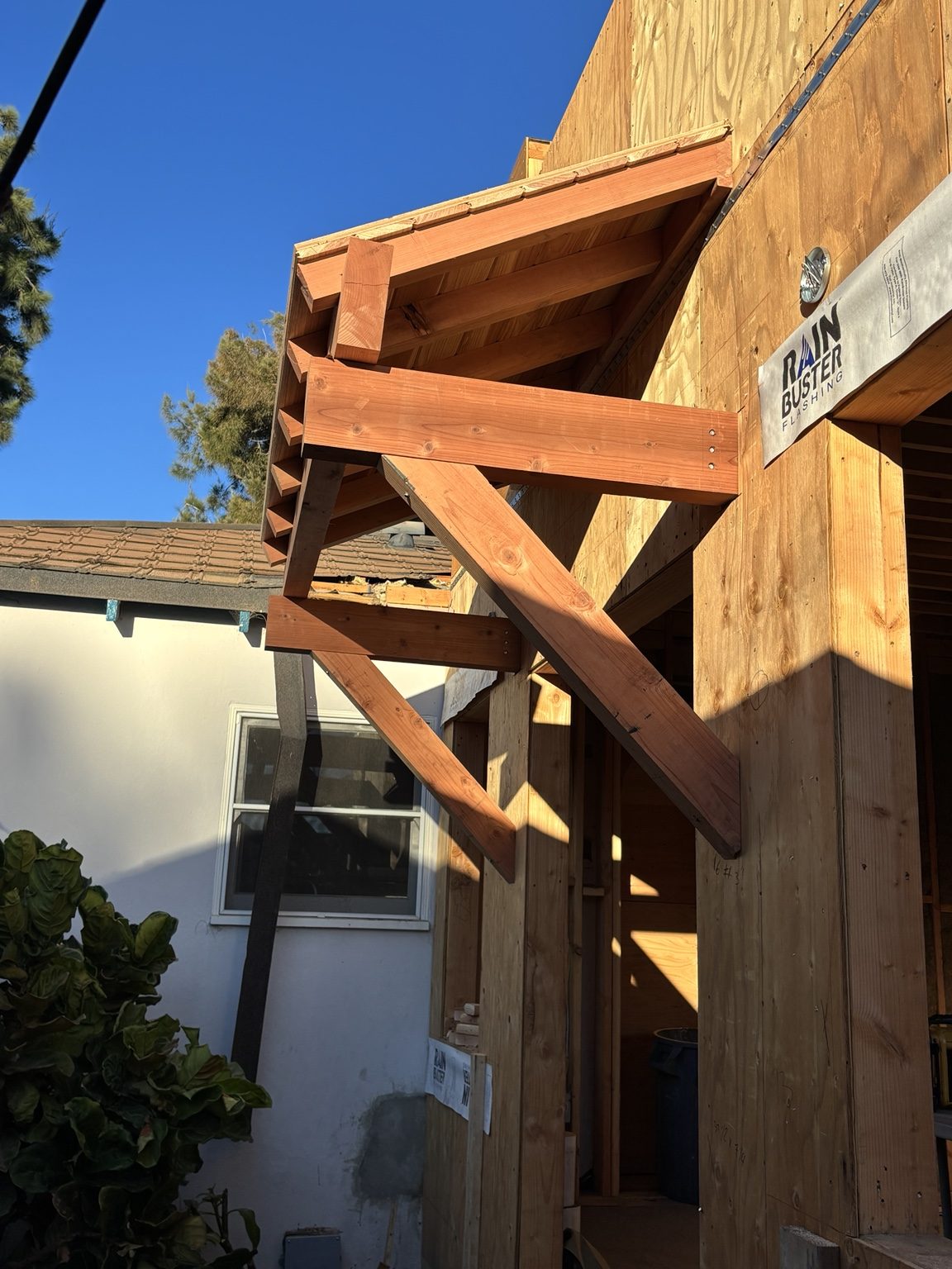 Redwood brackets and rafters framing the entry overhang