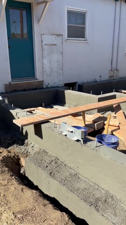 New concrete stem wall beside the existing house