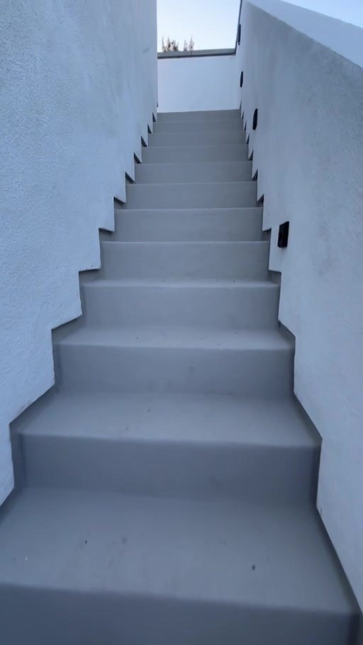 Stucco stairway leading up to the roof deck