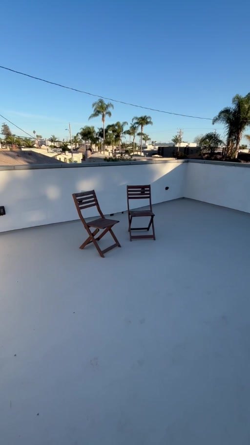 Roof deck with parapet walls and coated deck surface